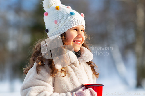 Image of little girl with cup of hot tea in winter park