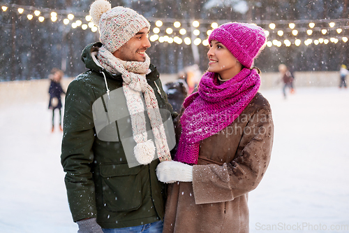 Image of happy couple at outdoor skating rink in winter