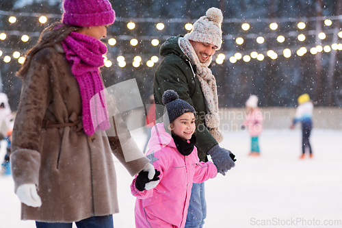 Image of happy family at outdoor skating rink in winter