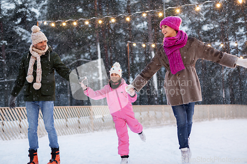 Image of happy family at outdoor skating rink in winter