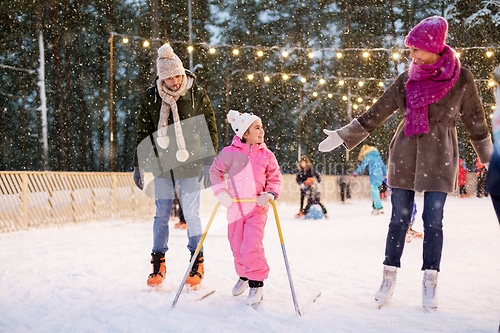 Image of happy family at outdoor skating rink in winter