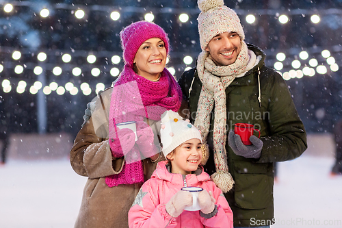 Image of happy family drinking hot tea on skating rink