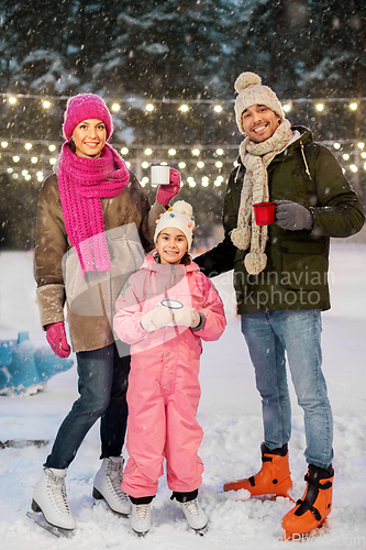 Image of happy family drinking hot tea on skating rink