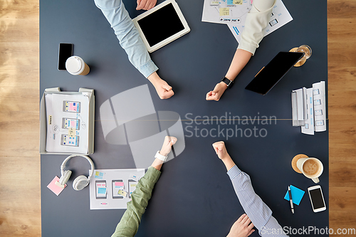 Image of business team showing thumbs up at office table