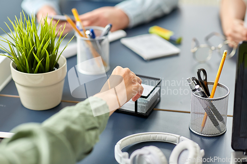 Image of businesswoman taking note paper at office