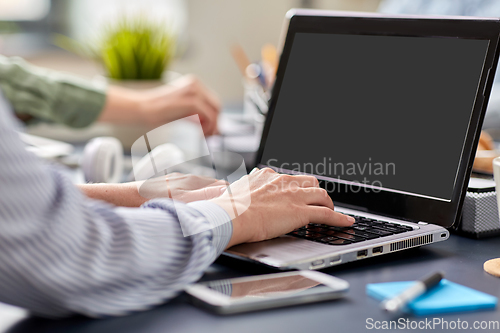 Image of businesswoman with laptop working at office