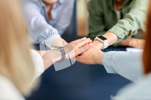 Image of close up of business team stacking hands
