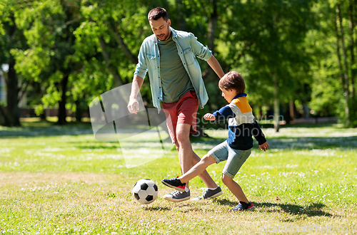 Image of father with little son playing soccer at park