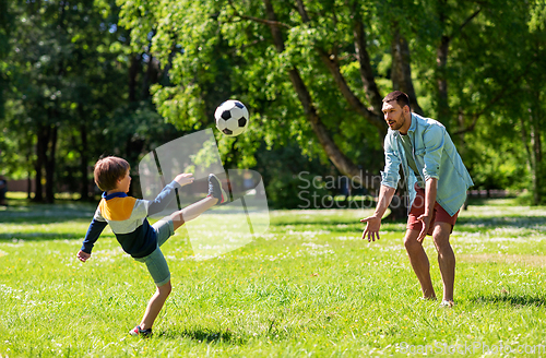 Image of father with little son playing soccer at park
