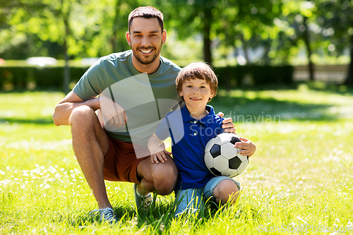 Image of father and little son with soccer ball at park