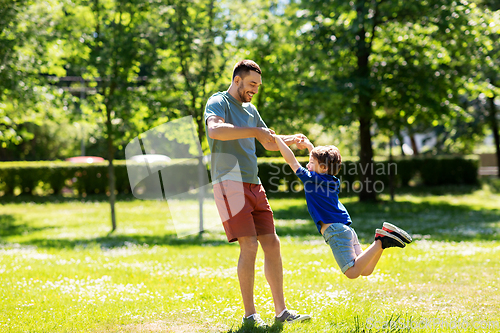 Image of happy father with son playing in summer park