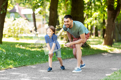 Image of happy father and son compete in running at park