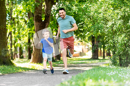 Image of happy father and son compete in running at park