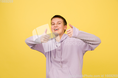 Image of Caucasian girl\'s portrait isolated on yellow studio background with copyspace