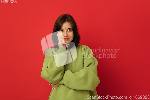 Image of Caucasian woman\'s portrait isolated on red studio background with copyspace