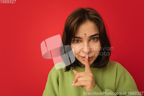 Image of Caucasian woman\'s portrait isolated on red studio background with copyspace