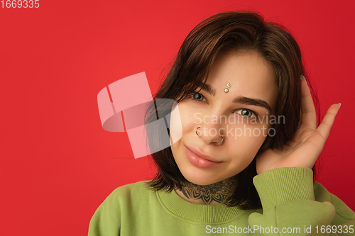 Image of Caucasian woman\'s portrait isolated on red studio background with copyspace