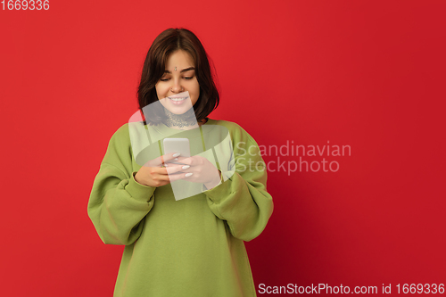 Image of Caucasian woman\'s portrait isolated on red studio background with copyspace