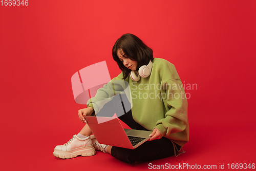 Image of Caucasian woman\'s portrait isolated on red studio background with copyspace