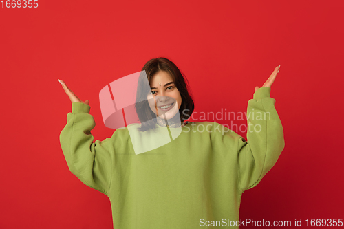 Image of Caucasian woman\'s portrait isolated on red studio background with copyspace