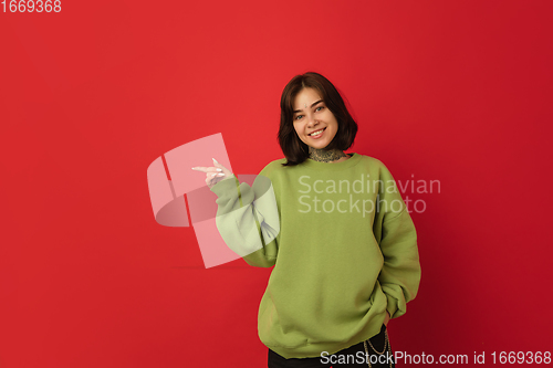 Image of Caucasian woman\'s portrait isolated on red studio background with copyspace