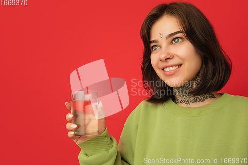 Image of Caucasian woman\'s portrait isolated on red studio background with copyspace