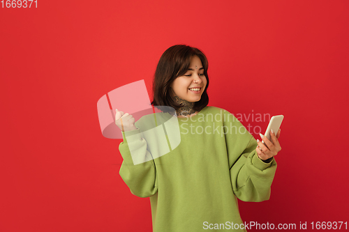 Image of Caucasian woman\'s portrait isolated on red studio background with copyspace