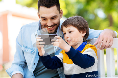 Image of father and son with smartphone at park