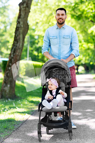 Image of happy father with child in stroller at summer park