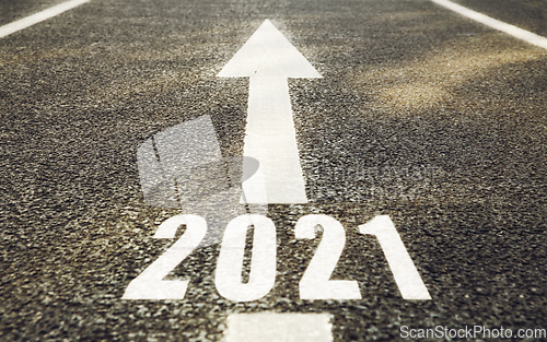 Image of white road marking in shape of 2021 year and arrow