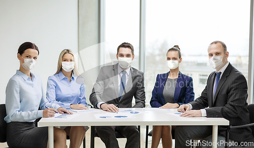 Image of business people in masks meeting at office