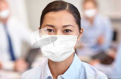 Image of businesswoman in face protective mask at office