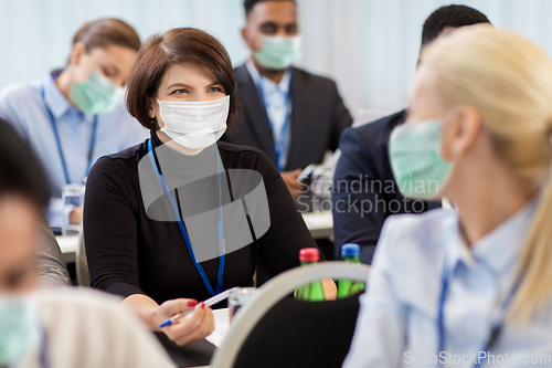 Image of business people in masks at conference