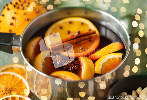 Image of pot with hot mulled wine, orange slices and spices