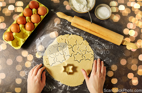 Image of hands with shortcrust pastry dough and star mold