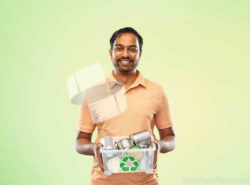 Image of smiling young indian man sorting metallic waste