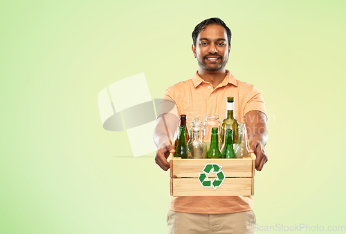 Image of smiling young indian man sorting glass waste