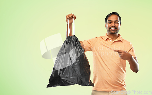 Image of smiling indian man holding trash bag