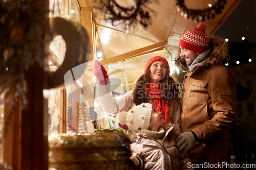 Image of happy family at christmas market in city