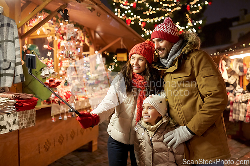 Image of happy family taking selfie at christmas market