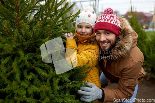 Image of happy family choosing christmas tree at market