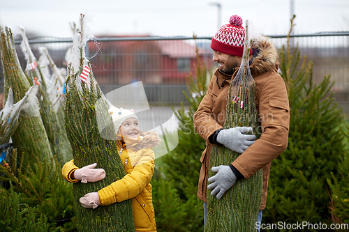 Image of happy family buying christmas tree at market