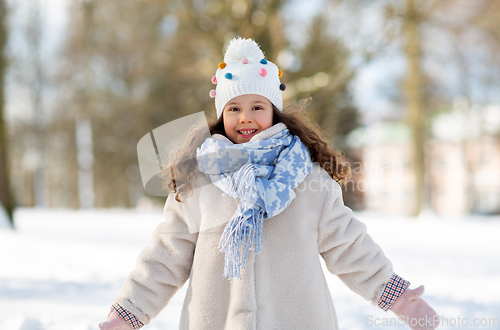 Image of happy little girl in winter clothes outdoors