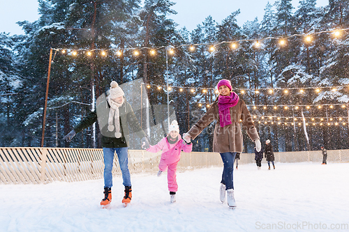 Image of happy family at outdoor skating rink in winter