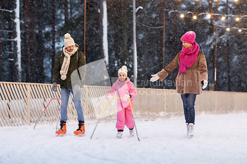 Image of happy family at outdoor skating rink in winter