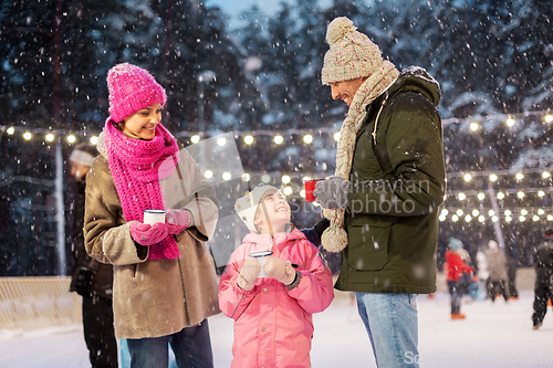 Image of happy family drinking hot tea on skating rink