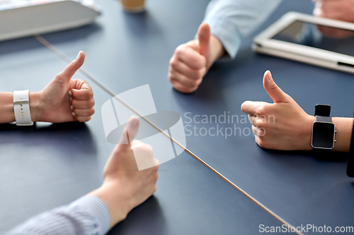 Image of close up of business team showing thumbs up