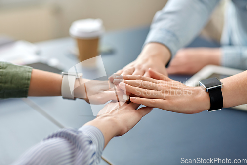 Image of close up of business team stacking hands