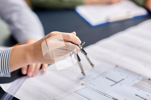 Image of architect with blueprint and drafting compass