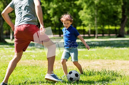 Image of father with little son playing soccer at park